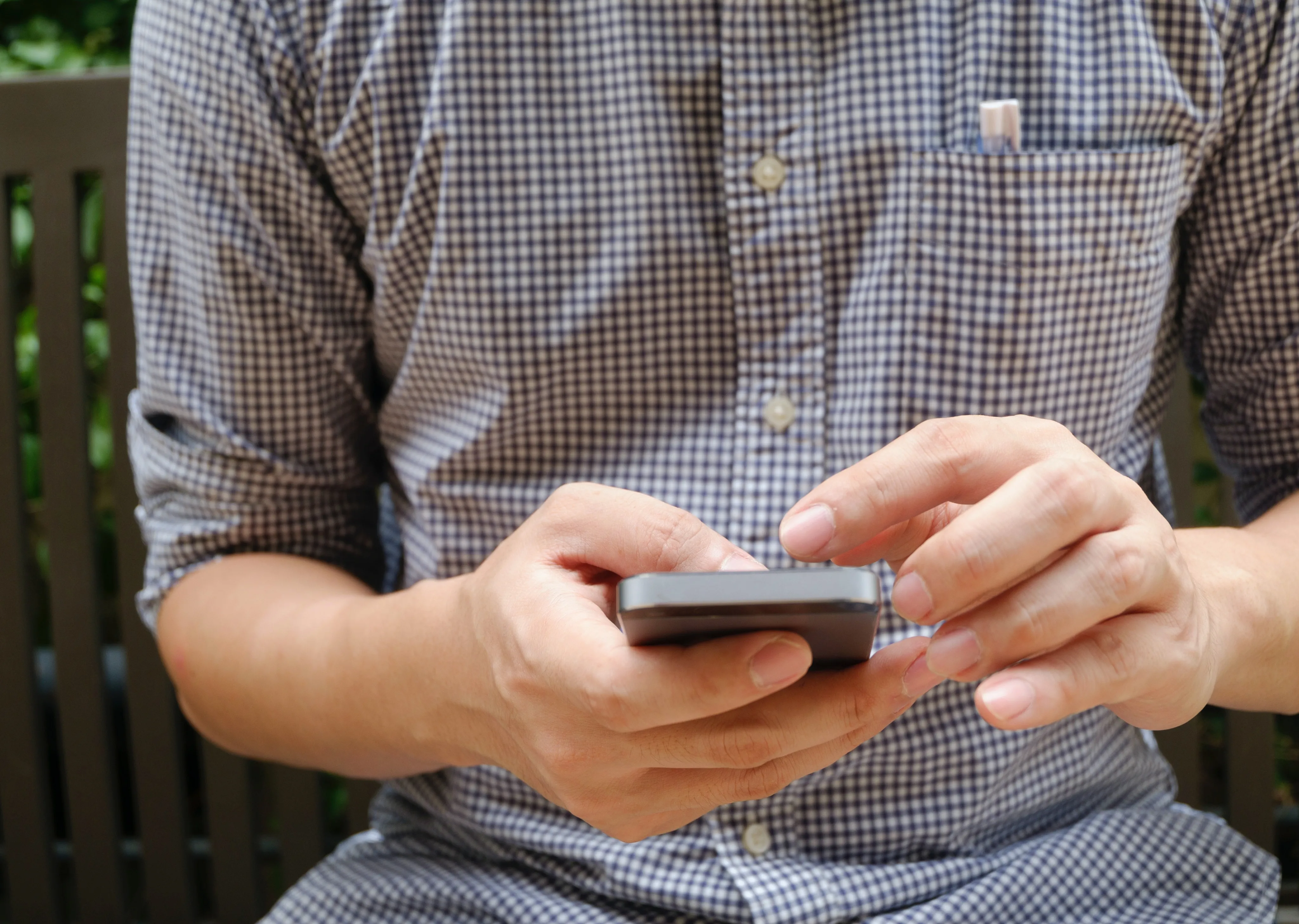 Hombre feliz agendando una hora en clínica Meru por medio de un celular